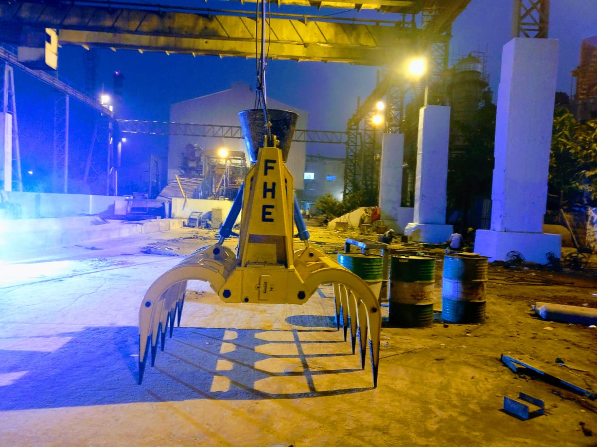FHE orange-peel grab suspended from a yard crane on site