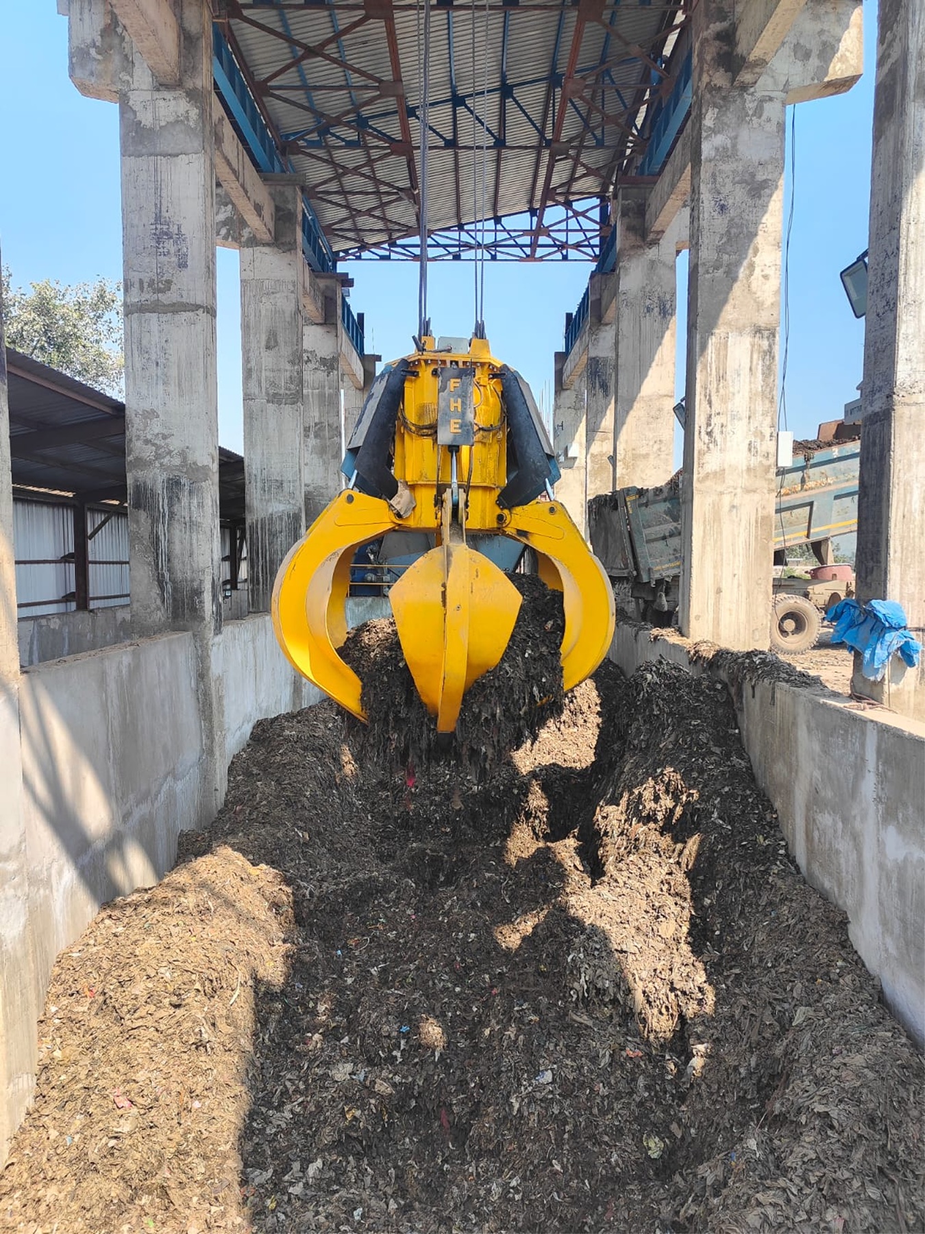 FHE orange-peel grab working a bulk waste handling pit